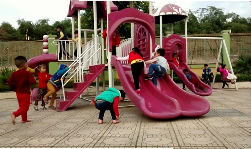 Bé thích thú khi chơi cầu trượt tại khu vui chơi ngoài trời