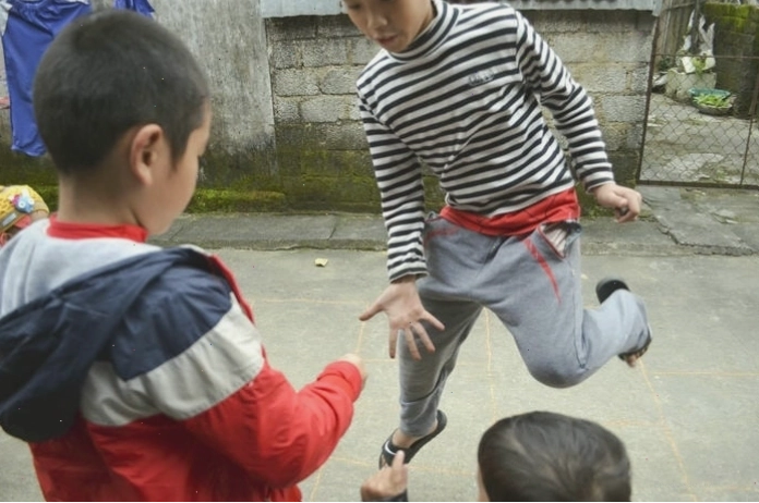 Cảnh các em nhỏ đang chơi nhảy lò cò trên sân